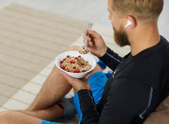 Man eating bowl of oatmeal after workout