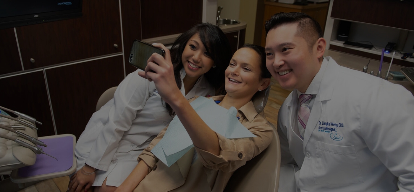 Dental patient taking a selfie with White Marsh dentist and assistant
